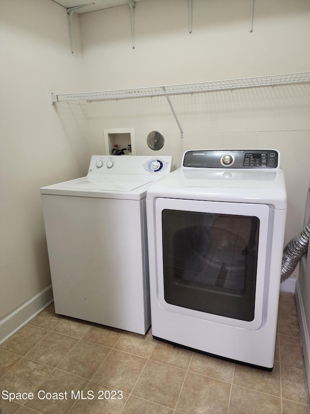 washroom featuring light tile floors, washer hookup, and washing machine and dryer