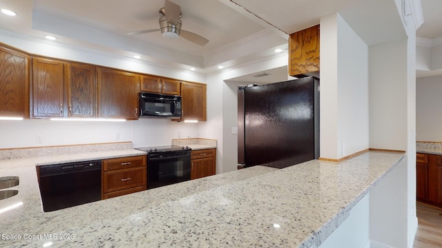 kitchen with ceiling fan, light stone counters, crown molding, light hardwood / wood-style flooring, and black appliances