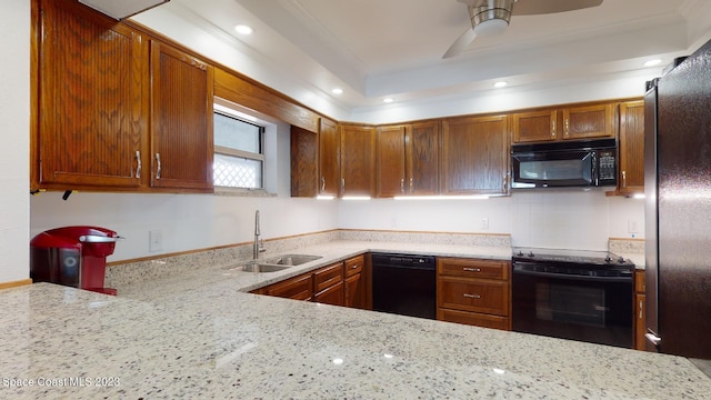 kitchen featuring ceiling fan, tasteful backsplash, black appliances, sink, and light stone counters