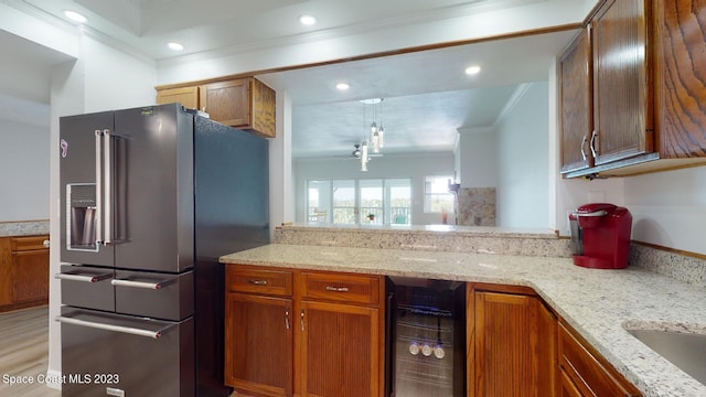 kitchen with high end refrigerator, light stone counters, ornamental molding, wine cooler, and light wood-type flooring