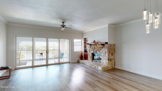 unfurnished living room featuring light hardwood / wood-style floors, a healthy amount of sunlight, ceiling fan, and a fireplace