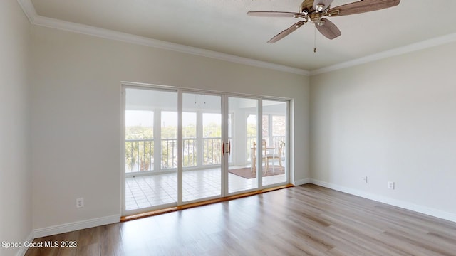 spare room featuring ornamental molding, ceiling fan, a wealth of natural light, and light wood-type flooring