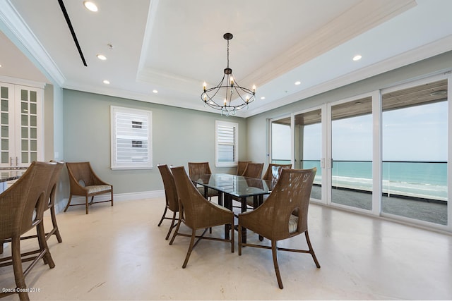 tiled dining room featuring french doors, a water view, a notable chandelier, and a tray ceiling