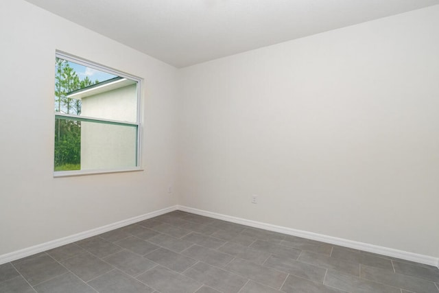 spare room featuring dark tile flooring