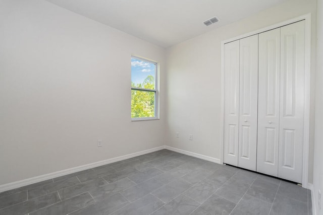 unfurnished bedroom with tile flooring and a closet