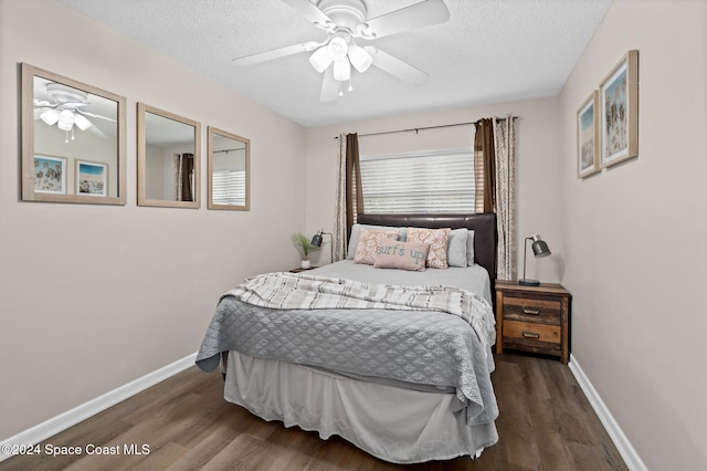 bedroom with a textured ceiling, dark wood-type flooring, and ceiling fan