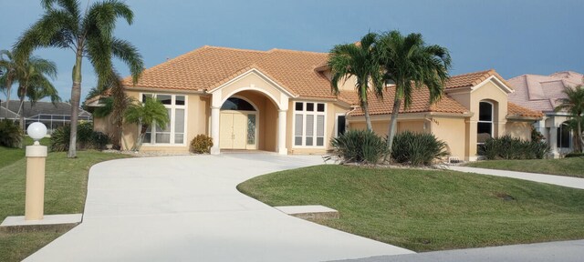 mediterranean / spanish house featuring a front yard