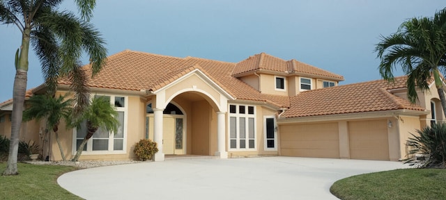 mediterranean / spanish-style home with a garage