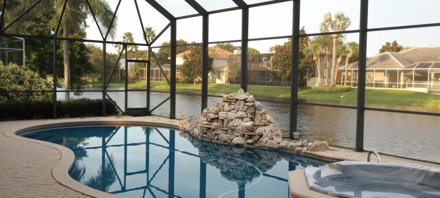 view of swimming pool with a lanai and a water view