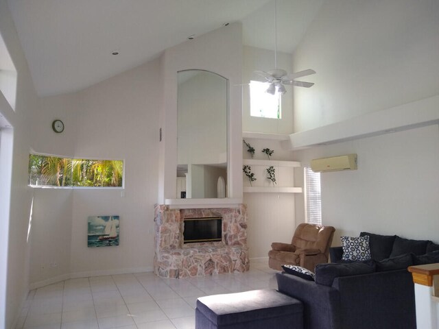 living room with light tile patterned flooring, ceiling fan, high vaulted ceiling, a wall unit AC, and a stone fireplace