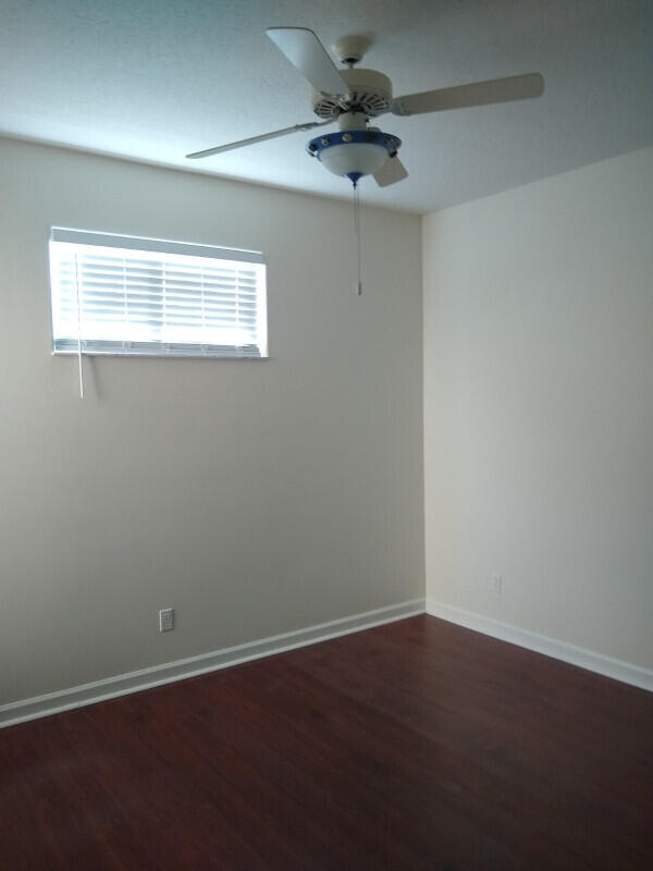 spare room with ceiling fan and wood-type flooring