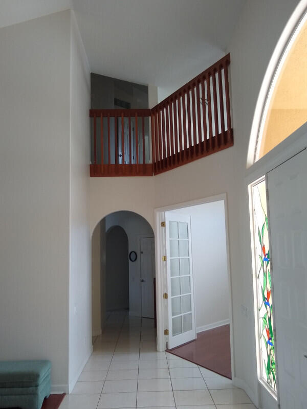 tiled entryway featuring a high ceiling and plenty of natural light