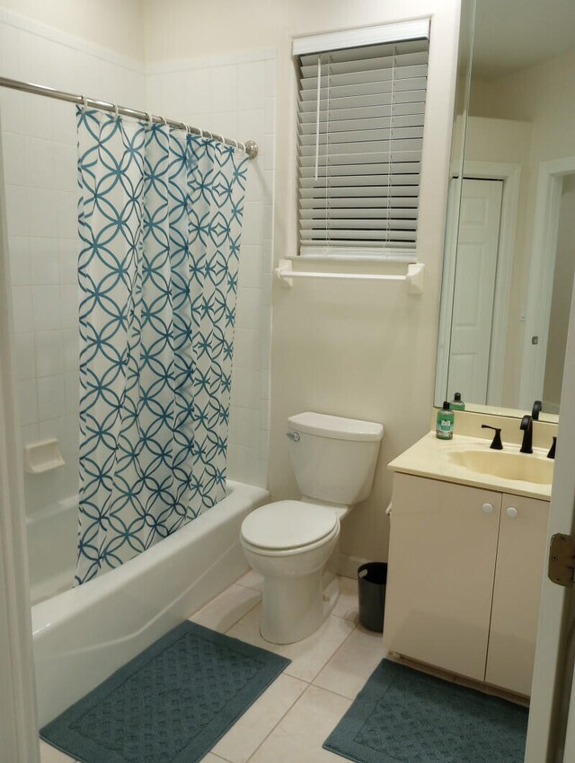 full bathroom featuring shower / bath combo with shower curtain, tile patterned floors, toilet, and vanity