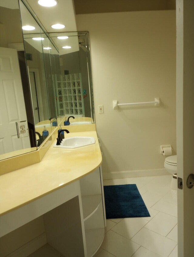 bathroom featuring vanity, tile patterned flooring, and toilet