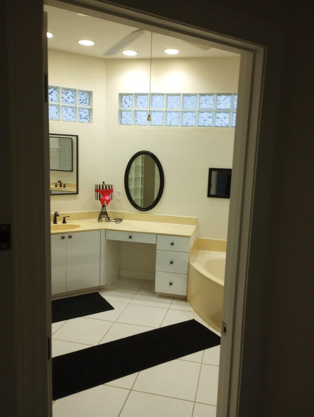 bathroom featuring vanity, tile patterned floors, and a tub to relax in