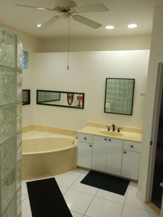 bathroom featuring tile patterned flooring, a bath, vanity, and ceiling fan