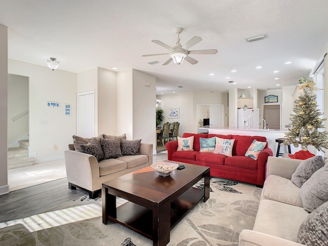 living room with sink, ceiling fan, and light hardwood / wood-style flooring