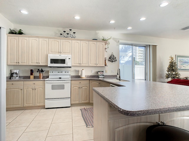 kitchen featuring light tile patterned flooring, kitchen peninsula, sink, and white appliances