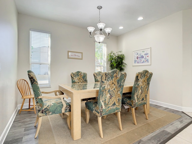 dining area with a notable chandelier, hardwood / wood-style floors, and a healthy amount of sunlight