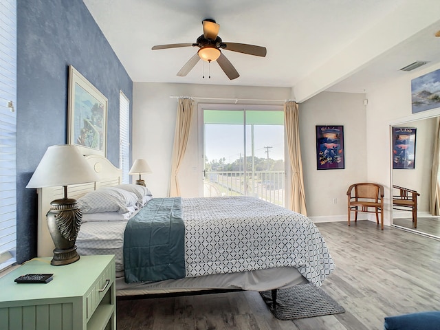 bedroom with beamed ceiling, hardwood / wood-style flooring, access to exterior, and ceiling fan