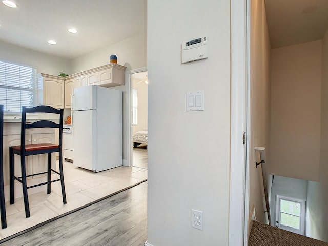 kitchen featuring plenty of natural light, light wood-type flooring, white refrigerator, and cream cabinetry