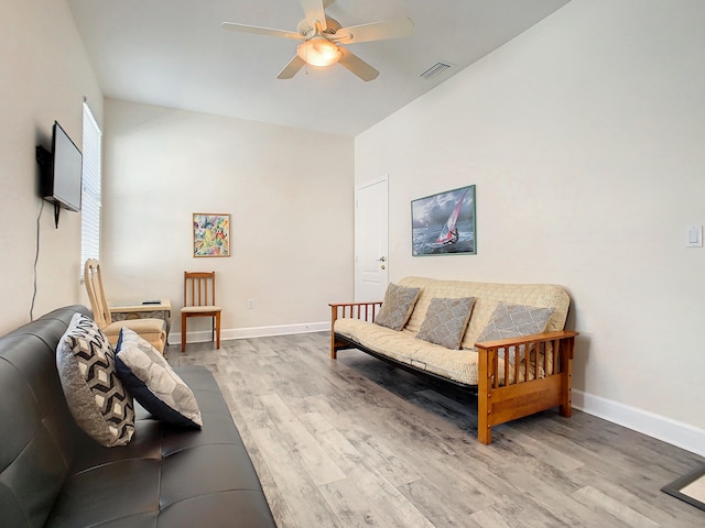 living room featuring light hardwood / wood-style floors, vaulted ceiling, and ceiling fan