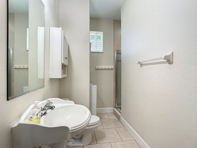 bathroom with tile patterned floors, a shower with shower door, and toilet