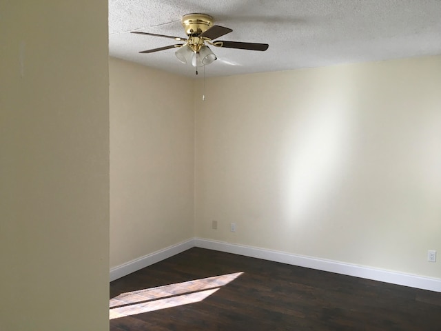 spare room featuring dark hardwood / wood-style flooring, a textured ceiling, and ceiling fan