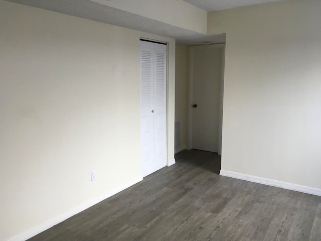 empty room with dark hardwood / wood-style floors