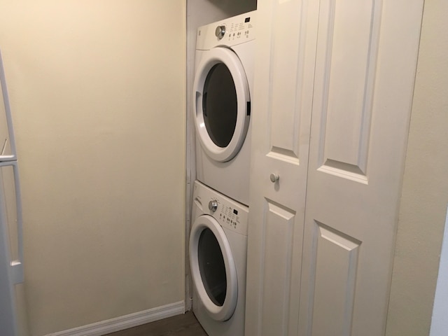 clothes washing area with stacked washer / dryer