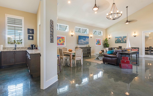 living room with high vaulted ceiling, sink, and an inviting chandelier