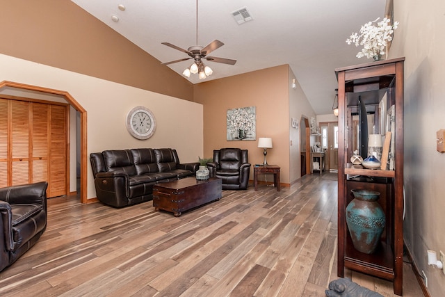 living room with high vaulted ceiling, ceiling fan, and light hardwood / wood-style flooring