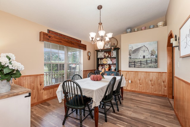 dining area with an inviting chandelier, vaulted ceiling, and dark hardwood / wood-style flooring