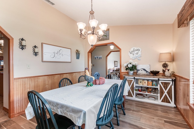 dining room featuring lofted ceiling, a notable chandelier, and wood-type flooring