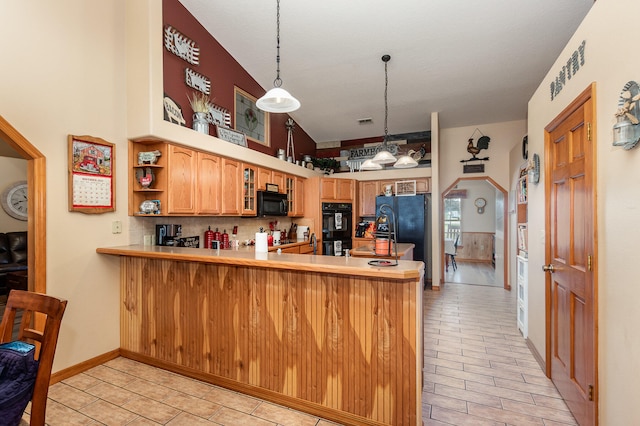 kitchen with kitchen peninsula, light tile floors, black appliances, decorative light fixtures, and lofted ceiling