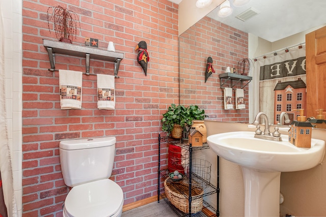 bathroom with brick wall