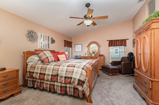 bedroom with a textured ceiling, light colored carpet, ceiling fan, and lofted ceiling