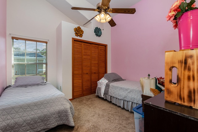 carpeted bedroom with a closet, ceiling fan, and high vaulted ceiling