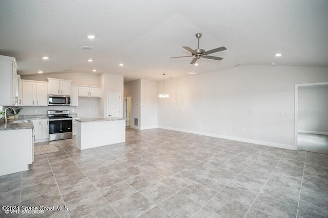 kitchen featuring stainless steel appliances, white cabinetry, sink, a center island, and vaulted ceiling