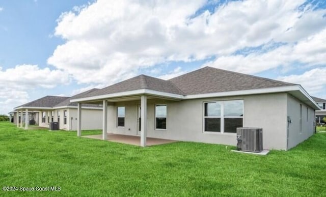 rear view of property featuring a patio, central AC, and a yard