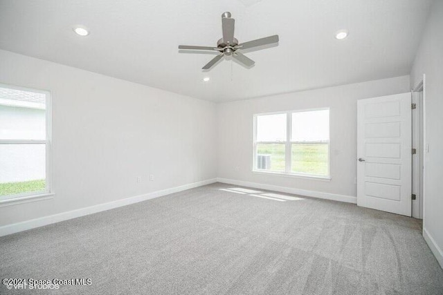 carpeted empty room featuring ceiling fan and a healthy amount of sunlight