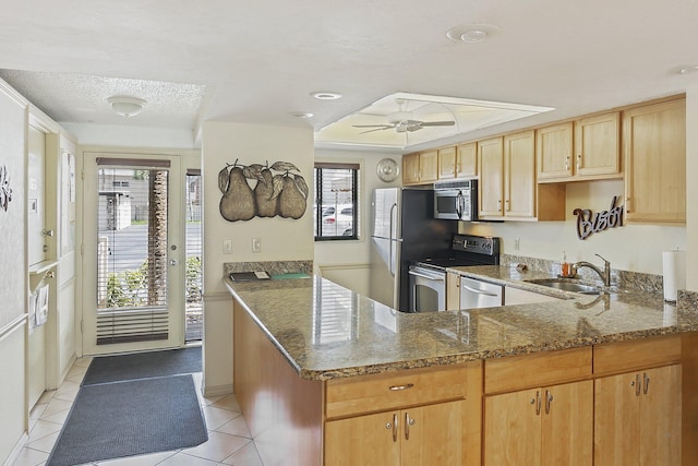 kitchen with ceiling fan, stone countertops, appliances with stainless steel finishes, sink, and light tile floors