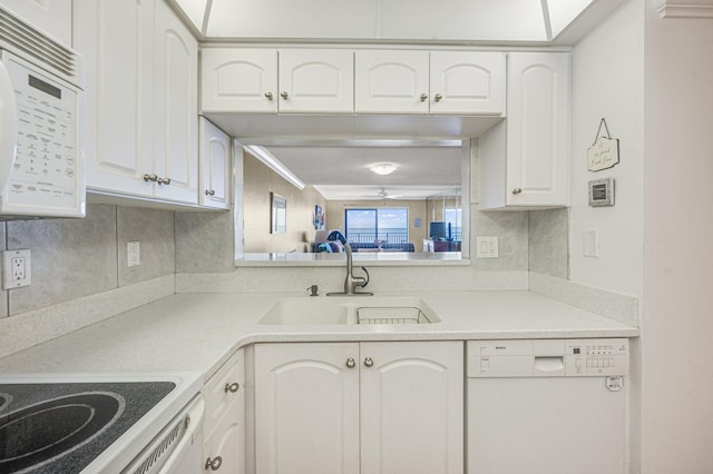 kitchen with backsplash, white appliances, white cabinets, and sink