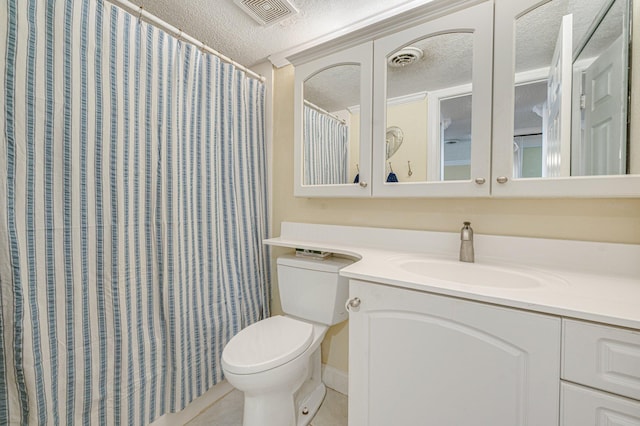 bathroom with a textured ceiling, large vanity, and toilet