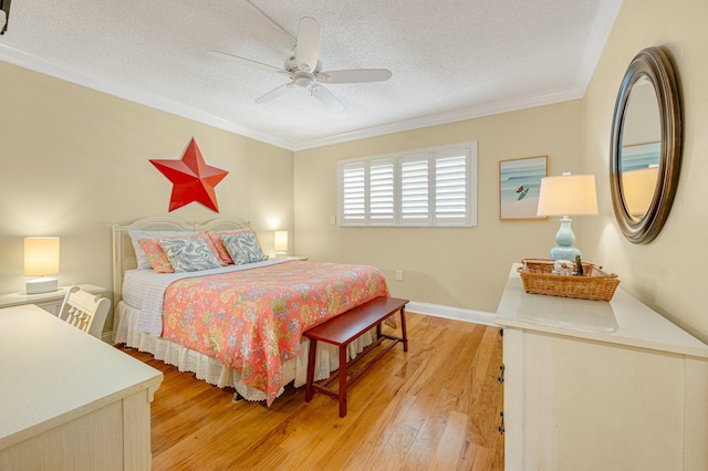 bedroom with a textured ceiling, light hardwood / wood-style floors, ceiling fan, and ornamental molding