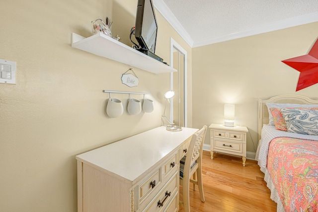 bedroom featuring ornamental molding, a textured ceiling, and light hardwood / wood-style flooring