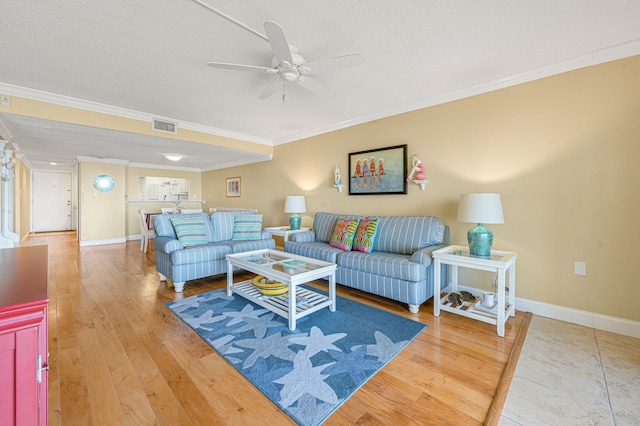 living room with light hardwood / wood-style floors, a textured ceiling, crown molding, and ceiling fan