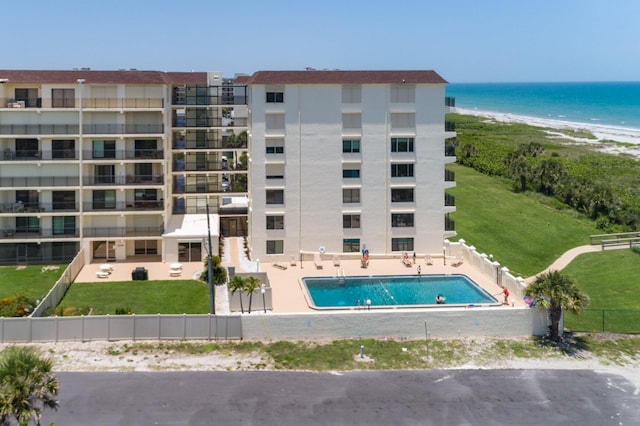 view of building exterior featuring a water view and a community pool