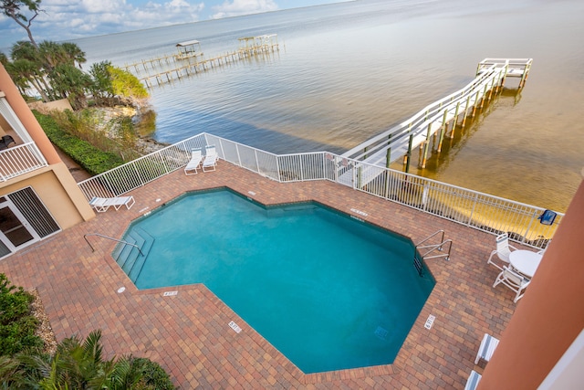 view of pool with a water view and a patio