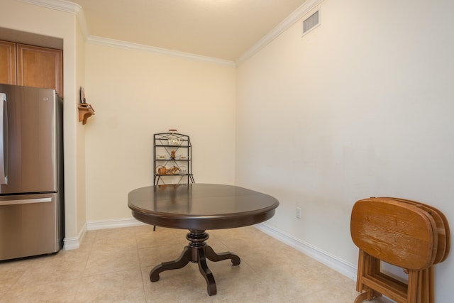 tiled dining space featuring crown molding